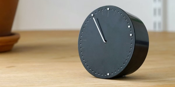 Black clock on wooden table